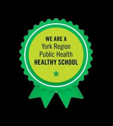 Green ribbon on black background. Inside circle, it reads We are a York Region Healthy School